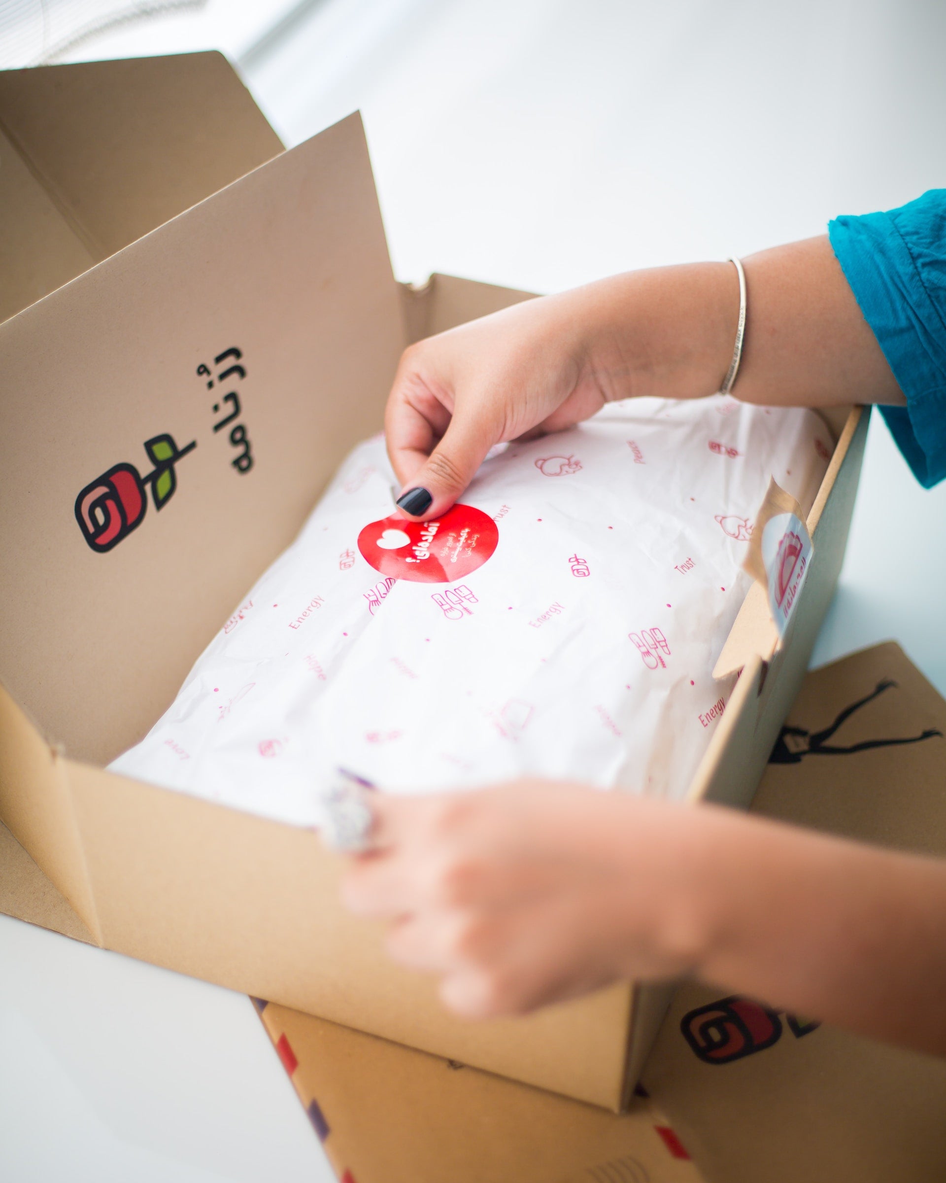 White Tissue Paper With A Red Logo in A Mailing Box